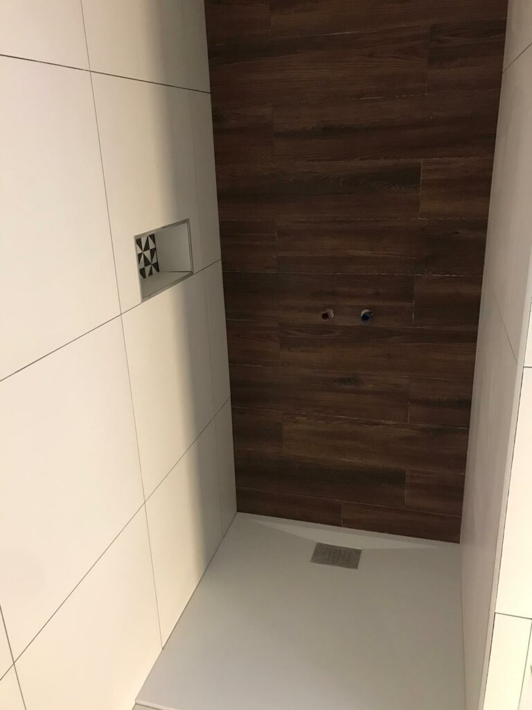 Carreleurs posant des carreaux dans une salle de bain à Thonon-les-Bains