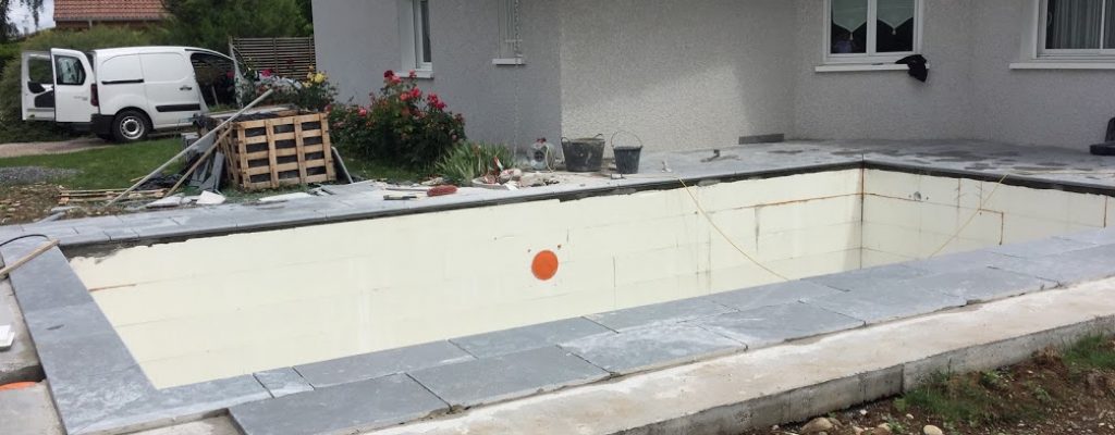 Carreleur travaillant sur une rénovation de piscine en pierre naturelle à Thonon-les-Bains