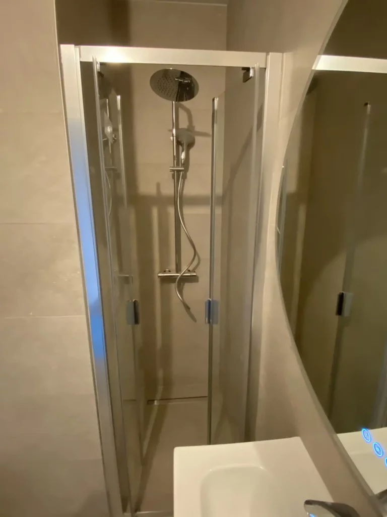 Douche moderne rénovée à Annemasse avec paroi vitrée et robinetterie contemporaine.