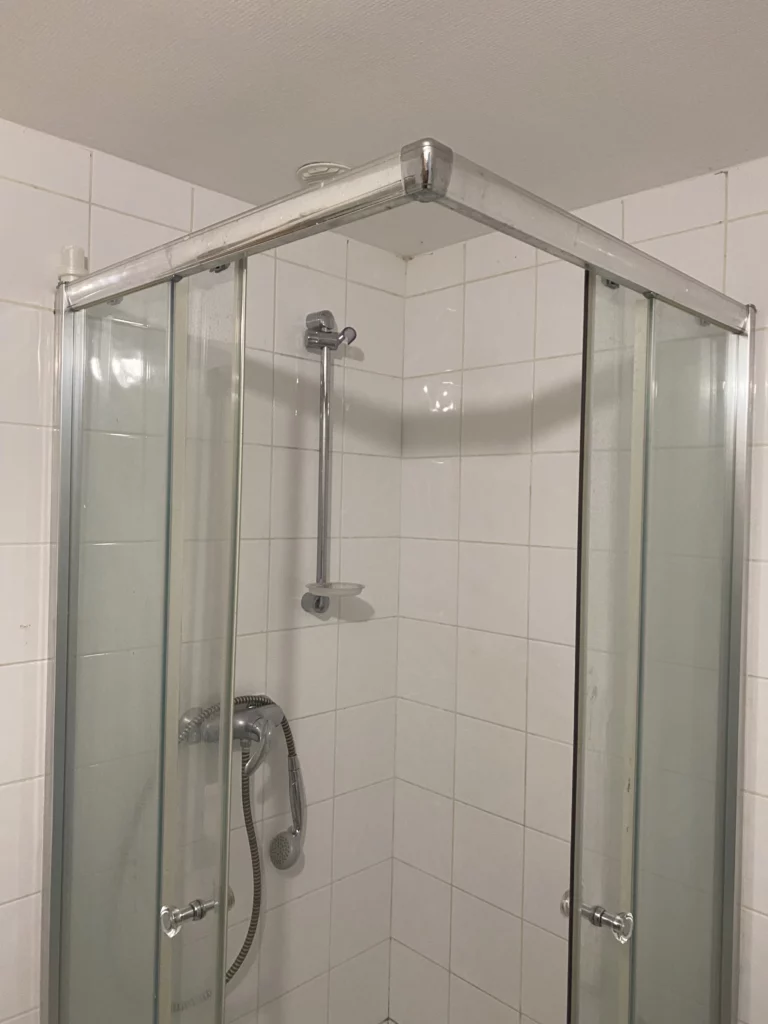 Carrelage mural blanc classique dans une cabine de douche à Bons-en-Chablais.