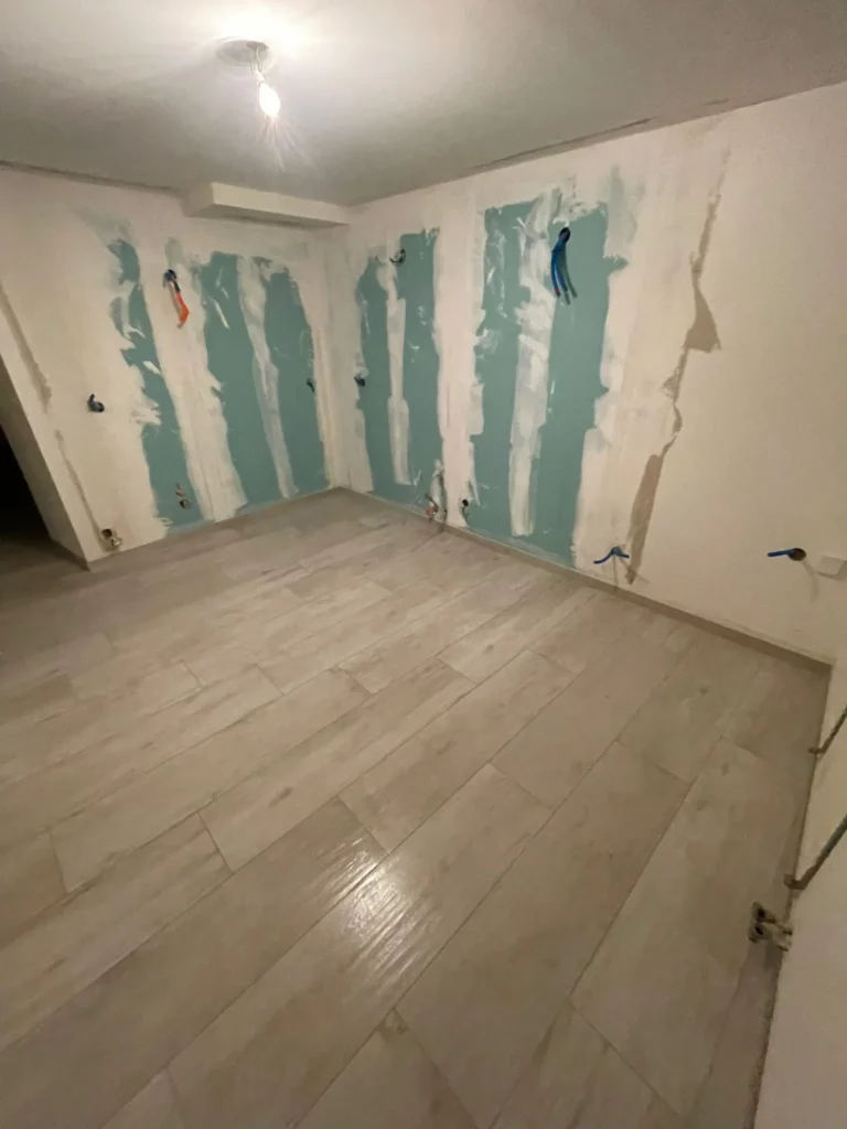 Pièce principale rénovée avec un carrelage effet bois à Bons-en-Chablais, vue large.