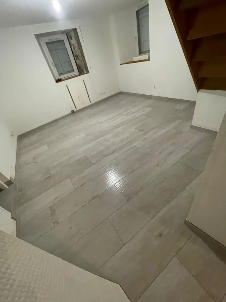 Vue plongeante sur un carrelage imitation bois gris beige pour une rénovation carrelage à Bons-en-Chablais.