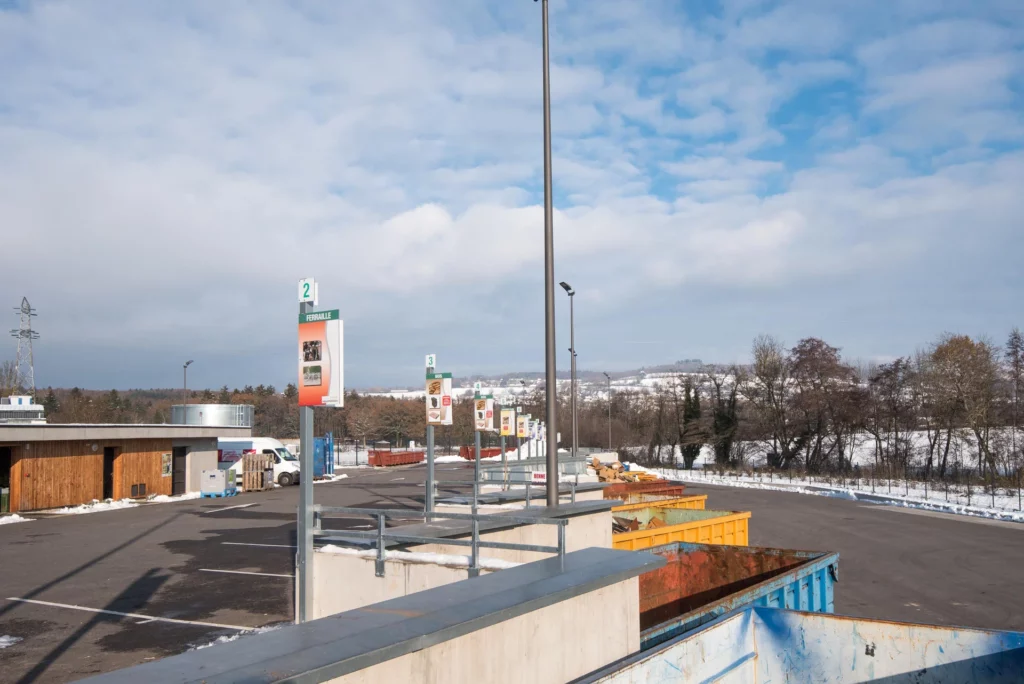Déchetterie sous la neige illustrant la gestion des déchets à Bons-en-Chablais, avec bennes de tri et zone ferraille.