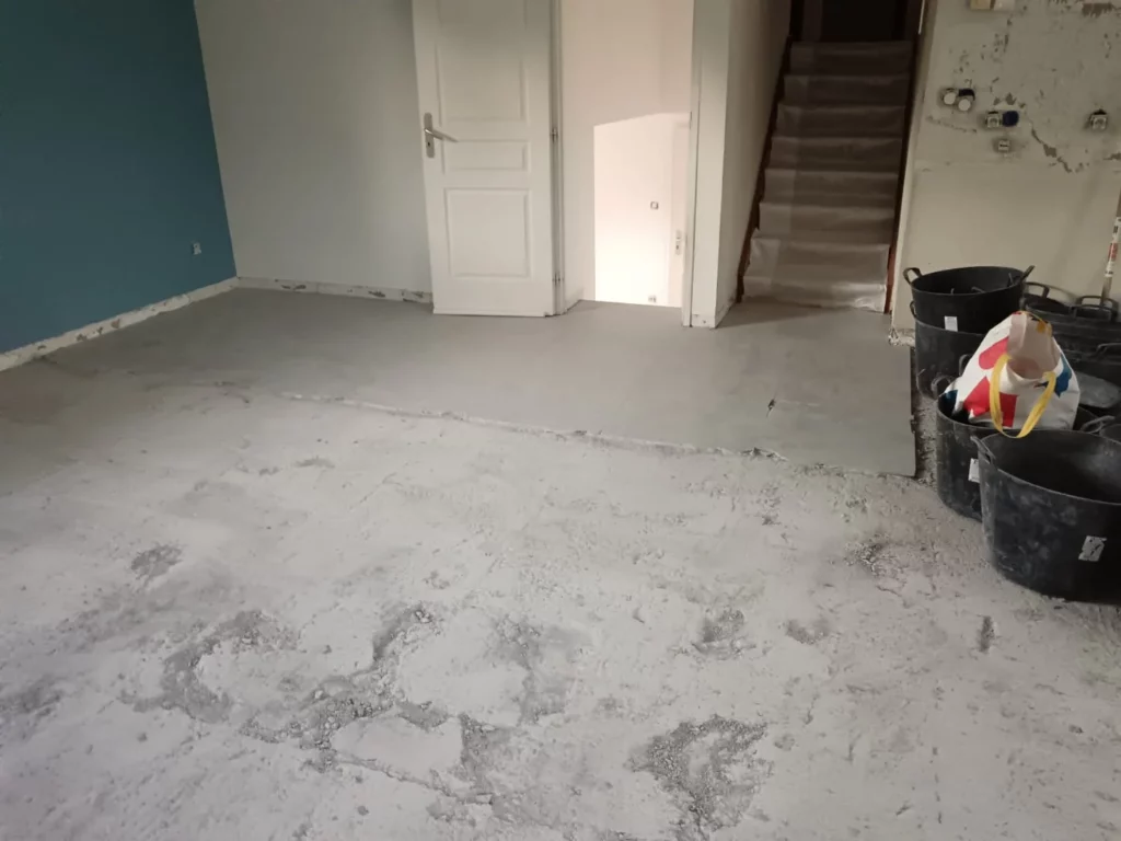 Chantier de démolition du carrelage à Excenevex : sol arraché, seaux de gravats et matériaux de rénovation