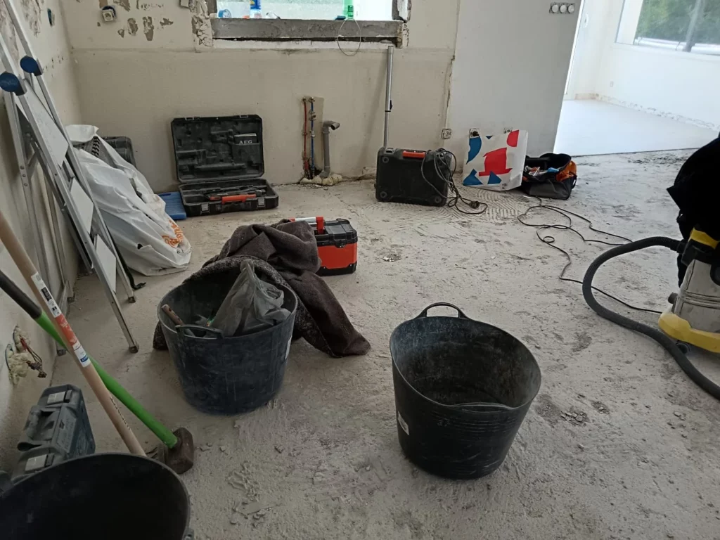 Démolition du carrelage d'une maison à Excenevex : pièce vidée avec outillage professionnel et chape dégagée