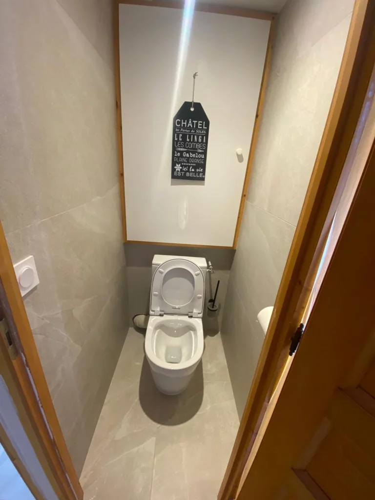 Rénovation salle de bain à Châtel avec WC rénové et carrelage beige grand format