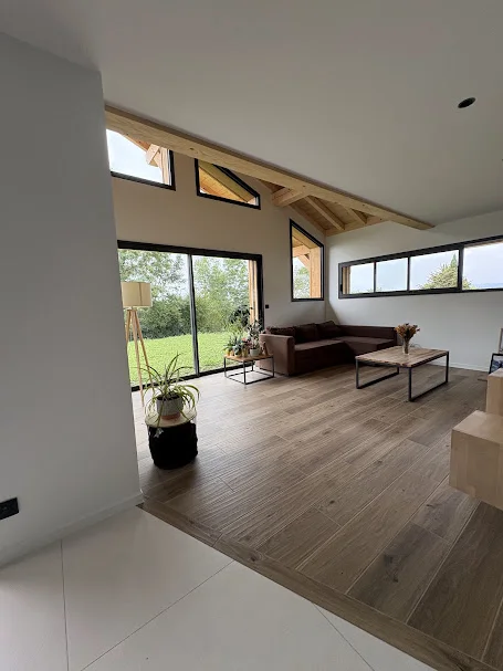 Pose de carrelage effet bois dans un salon avec charpente à Ballaison