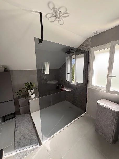 Douche italienne avec paroi noire et carrelage effet pierre à Gaillard