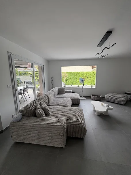 Salon moderne avec carrelage gris après rénovation à Gaillard