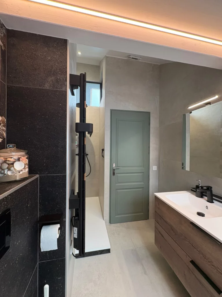 Rénovation d'une salle de bain à Fessy : douche, meuble vasque en bois et porte verte après travaux